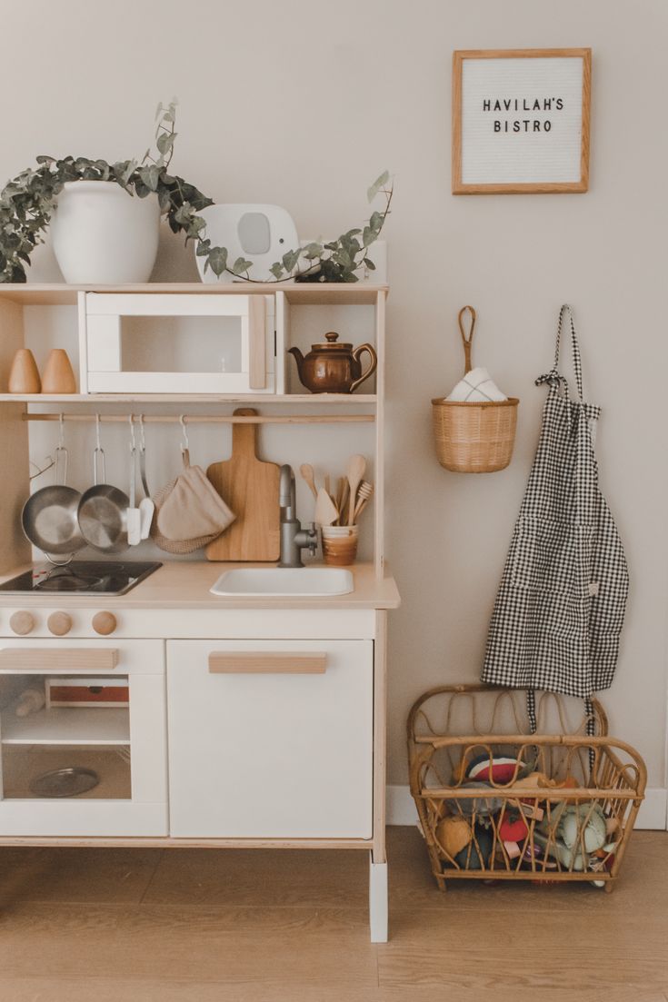 a kitchen with white cupboards and shelves filled with pots, pans and utensils