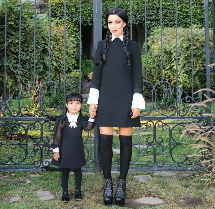 a woman and child standing in front of a gate