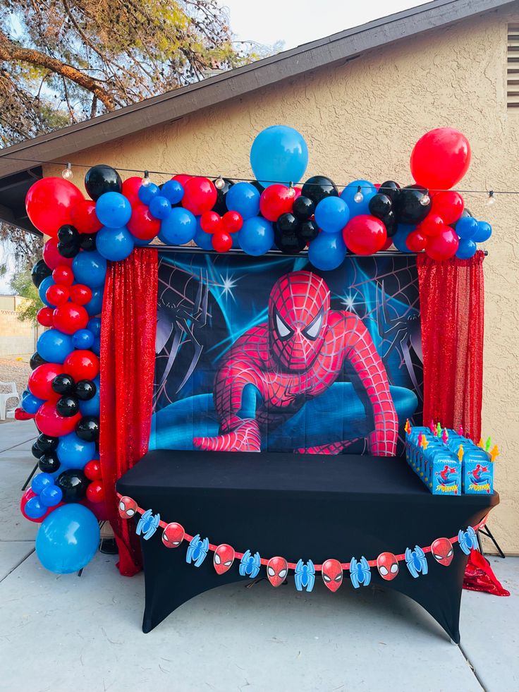 a spiderman birthday party with balloons and decorations