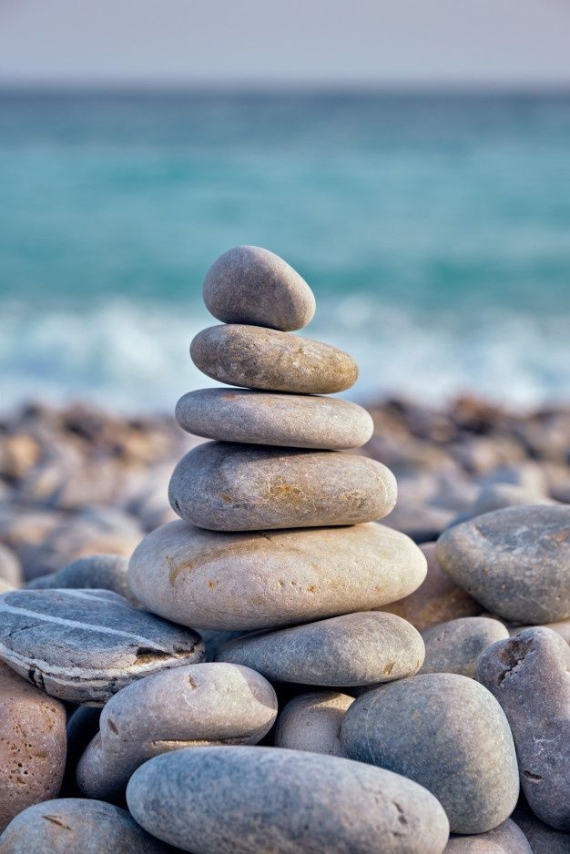 rocks stacked on top of each other in front of the ocean - stock photo - images