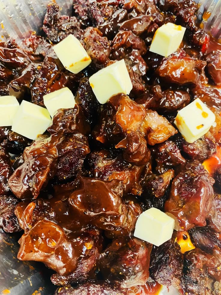 a bowl filled with meat and cheese on top of a wooden table next to other food items