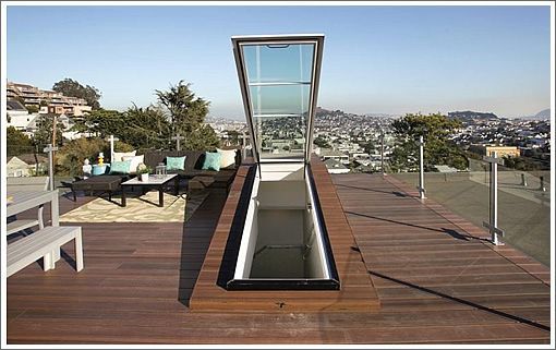 an open window on the side of a building with a view of city in the background