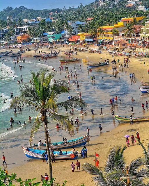 many people are on the beach with boats and palm trees in the foreground,