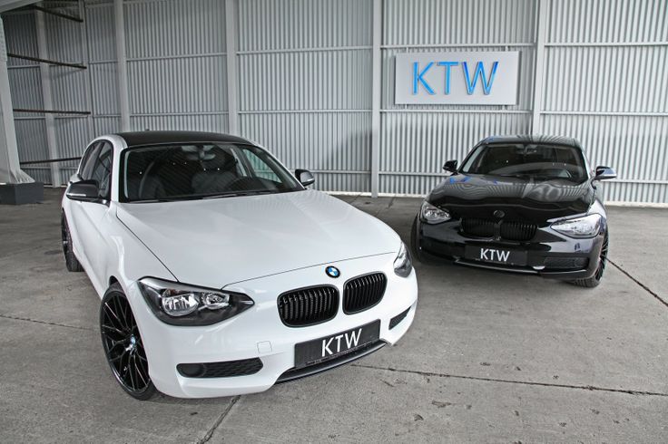 two white cars parked next to each other in front of a building with the ktw logo on it