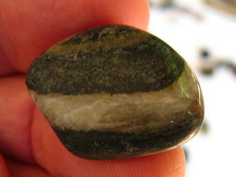 a close up of a person holding a small rock in their left hand and the other hand is holding it