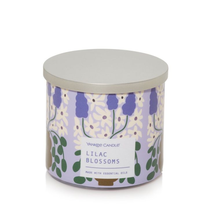 a candle that is in a tin with flowers on it and the words lilac blossoms written