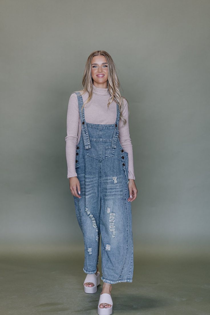 Frankie Denim Overalls are crafted from washed denim for a stylish, weathered look. Featuring an oversized and loose fit with adjustable straps and distressed details, these overalls are designed to provide a comfortable, personalized fit. Model Measurements: Hips 34” Waist 25” Bust 32” Height 5’6.5, wearing a size small Material: 100 Cotton Measurements XS: Hips: 42"| Length: 44" (taken from top of front of overalls to ankle cuff) S: Hips: 42"| Length: 44.5" (taken from top of front of overalls to ankle cuff) M: Hips: 46" | Length: 45" (taken from top of front of overalls to ankle cuff) L: Hips: 48" | Length: 45.5" (taken from top of front of overalls to ankle cuff) Trendy Distressed Medium Wash Denim Jumpsuit, Trendy Distressed Dark Wash Denim Jumpsuit, Trendy Dark Wash Distressed Denim Jumpsuit, Distressed Light Wash Denim Overall Jumpsuit, Light Wash Distressed Denim Overall Jumpsuit, Medium Wash Denim Jumpsuit With Frayed Hem, Distressed Light Wash Denim Jumpsuit, Distressed Overalls For Fall, Distressed Light Wash Denim Overalls