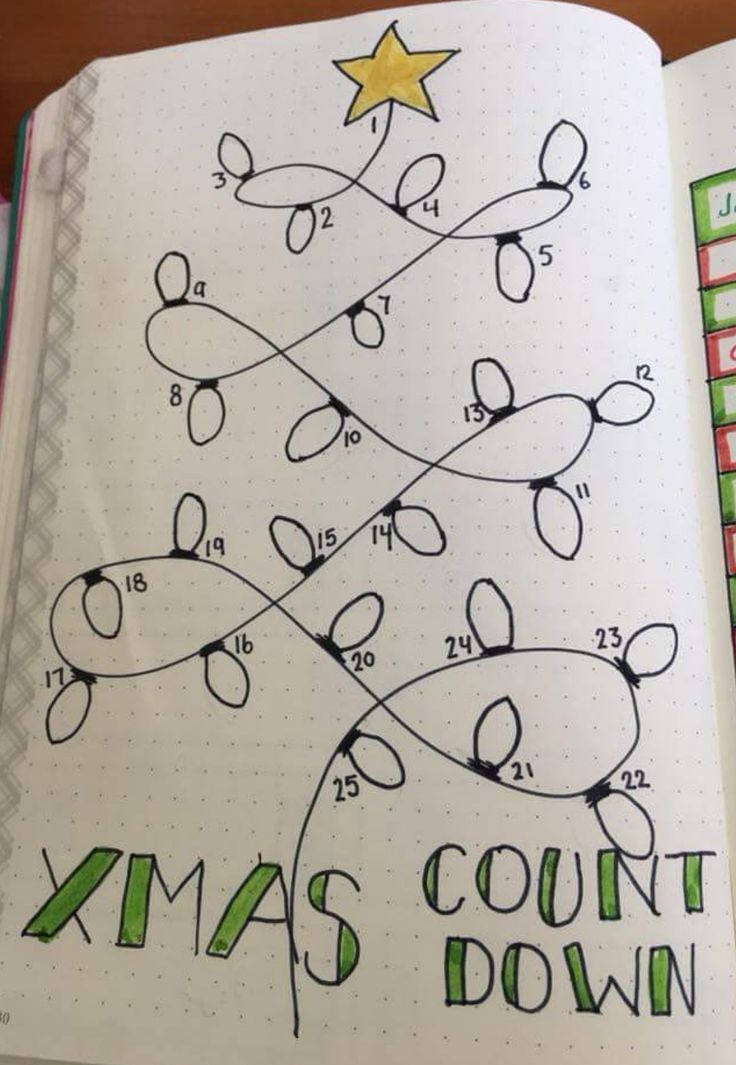 an open notebook with christmas tree drawn on the pages and numbers in each corner,