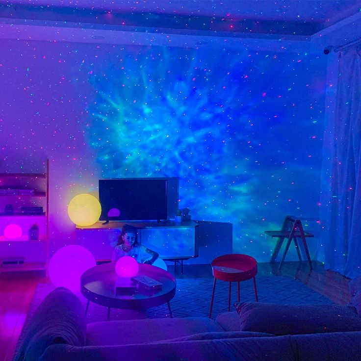 a living room with purple and blue lights on the ceiling, stars in the background