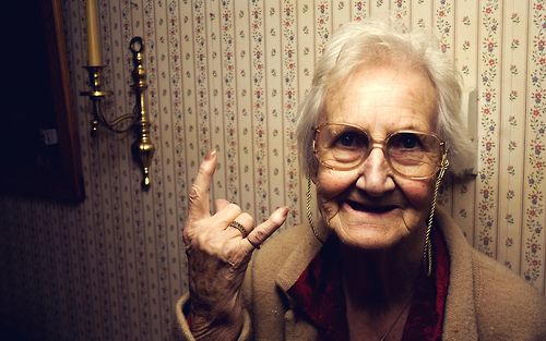 an old woman making the peace sign with her hand and saying, immatility you don't stop early when you get old