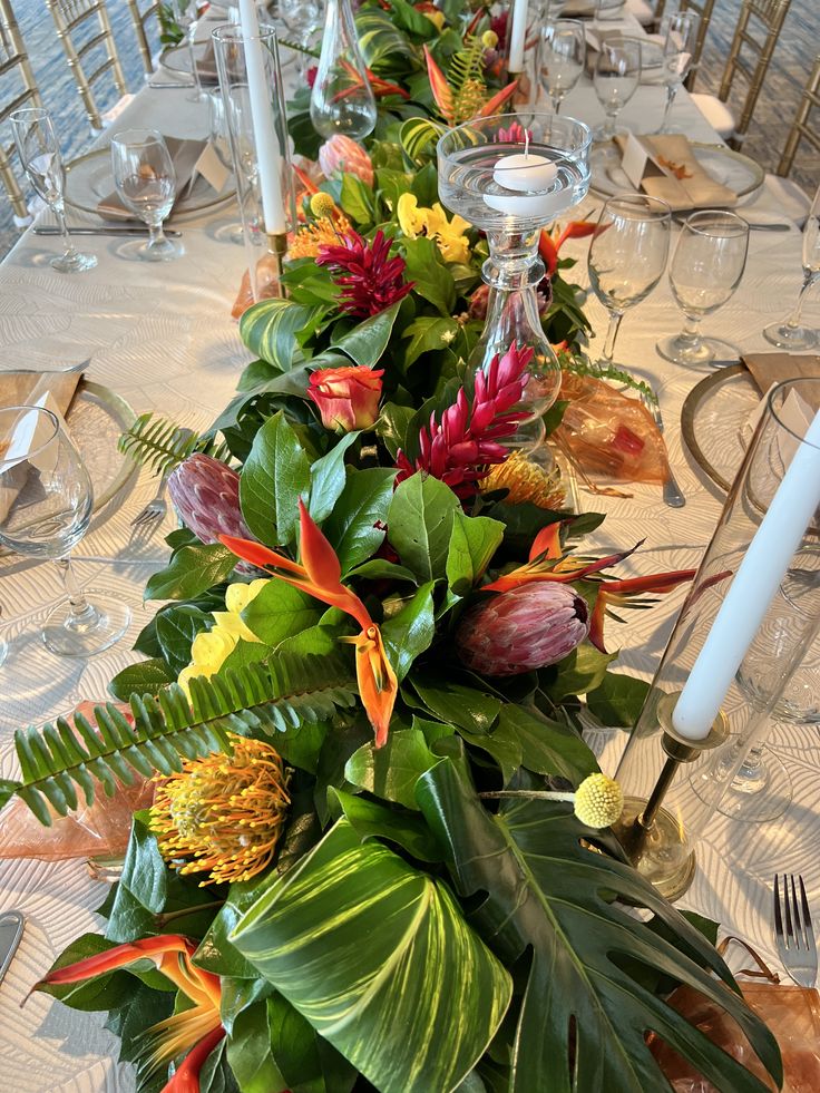 a long table with flowers and greenery on it