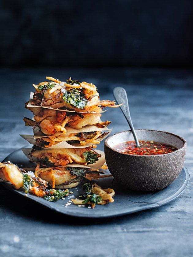 a stack of food sitting on top of a plate next to a bowl of soup