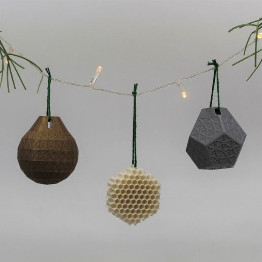 three hanging ornaments made out of wood and string