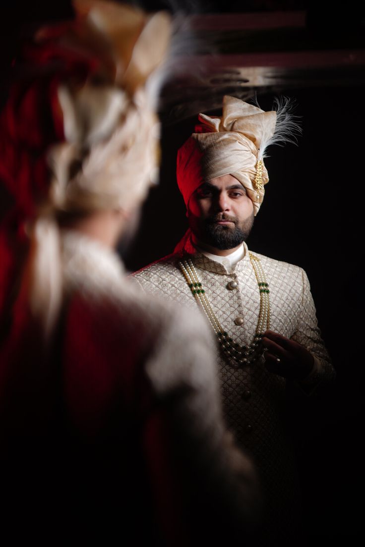 a man in a turban looking at his reflection