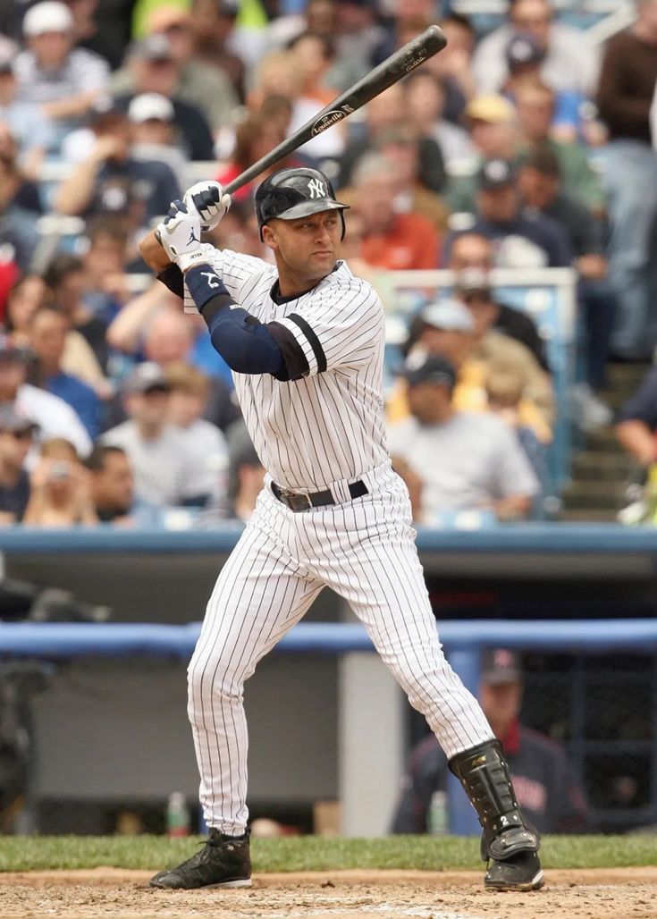 a baseball player holding a bat on top of a field in front of a crowd