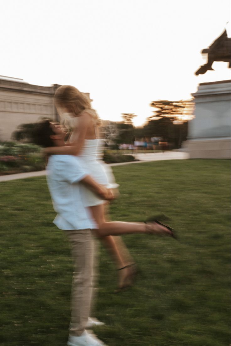 a man and woman are playing in the grass