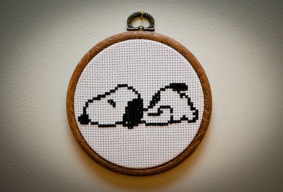 a cross - stitch hoop hanging on the wall with two dogs in it's eyes