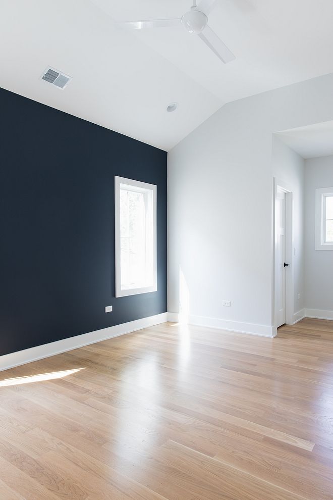 an empty room with blue walls and wood floors