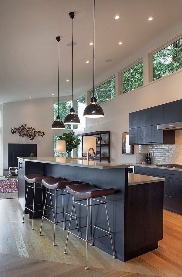 a kitchen with an island and bar stools in the center, surrounded by wood flooring