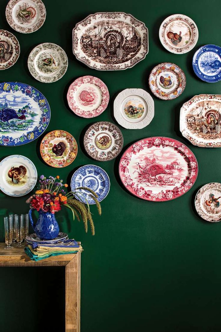 many plates are arranged on the wall above a table