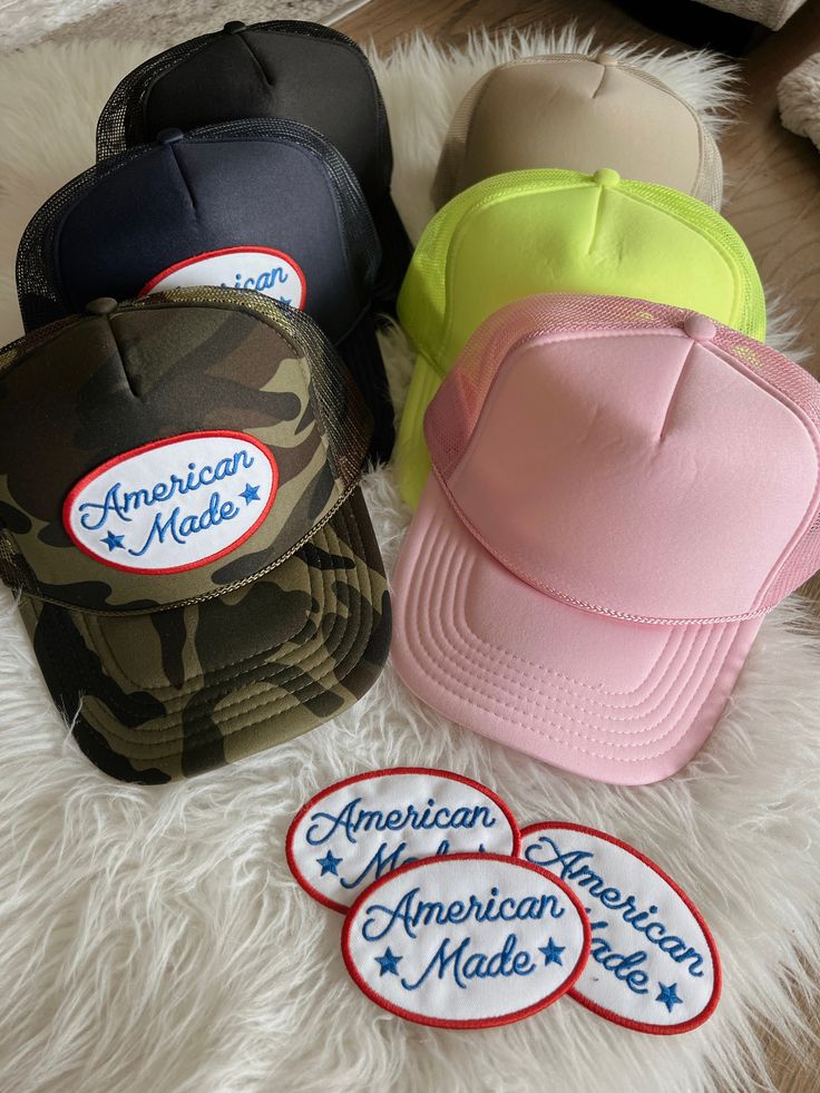 Camo, khaki, navy, light pink, or neon yellow high crown foam snap back trucker hat detailed with American Made patch Trendy Snapback Hat With Logo Patch For Streetwear, Trucker Snapback Hat With Patches, Trucker Style Snapback Baseball Cap With Patches, Trucker Snapback Hat With Patches For Streetwear, Trucker Style Snapback Hat With Patches For Streetwear, Trucker Snapback Hat With Patches And Curved Bill, Trucker Hat With Letter Patch Snapback, Snapback Trucker Hat With Patches, Adjustable Snapback Trucker Hat With Patches