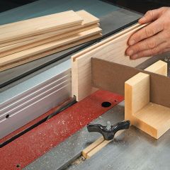 a person using a table saw to cut wooden planks on a piece of wood