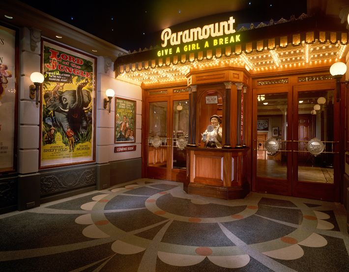 an entrance to a movie theater at night