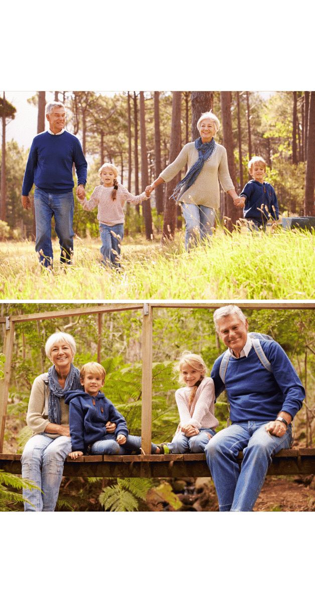 an older man, woman and two children are sitting on a bench in the woods