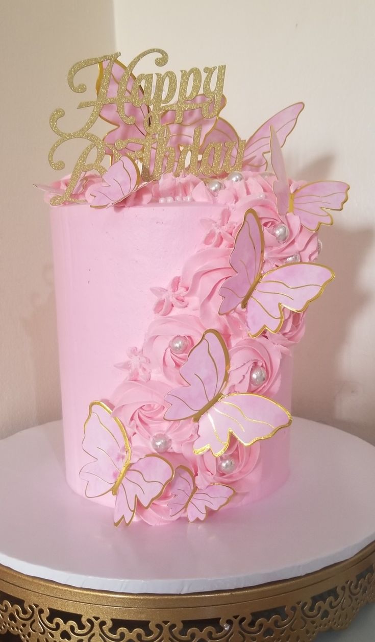 a pink and gold birthday cake decorated with butterflies