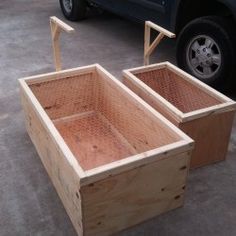 two wooden boxes sitting on the ground next to a black pickup truck in a parking lot