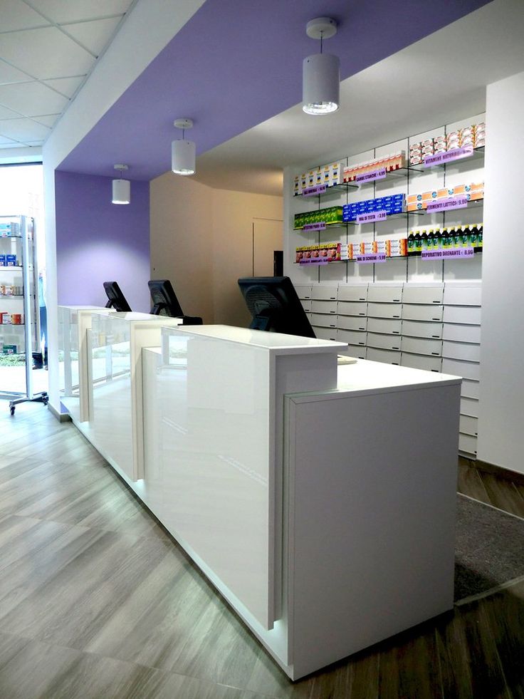 the front desk of a pharmacy with many medicine bottles on it's wall and shelving