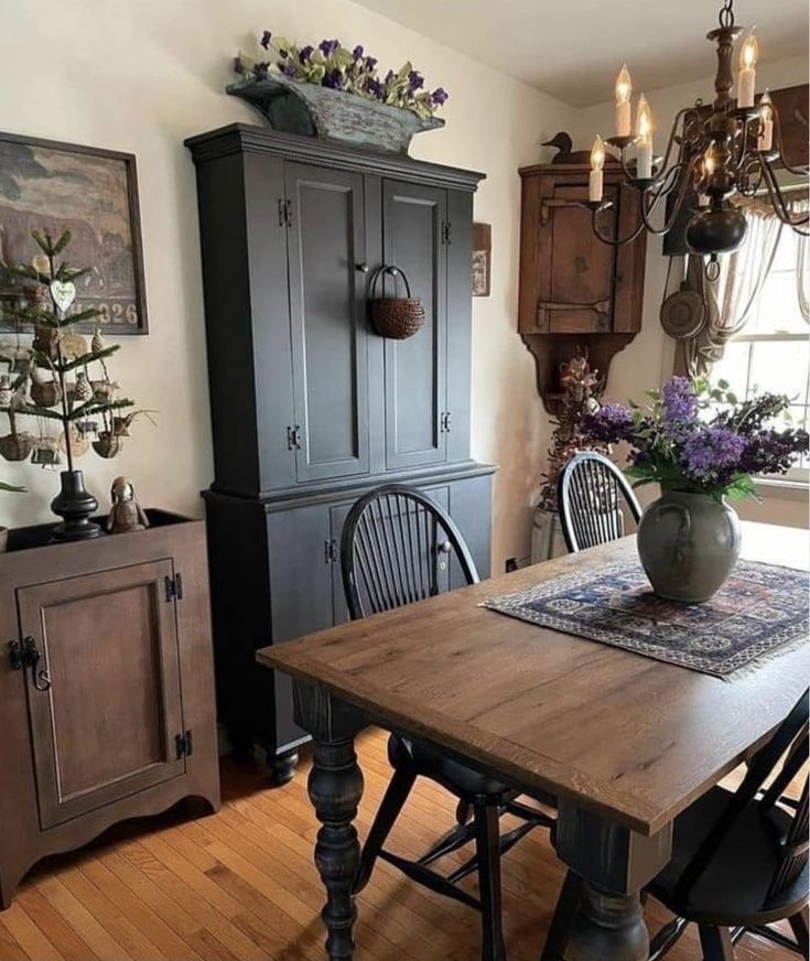 a dining room table with chairs and an armoire