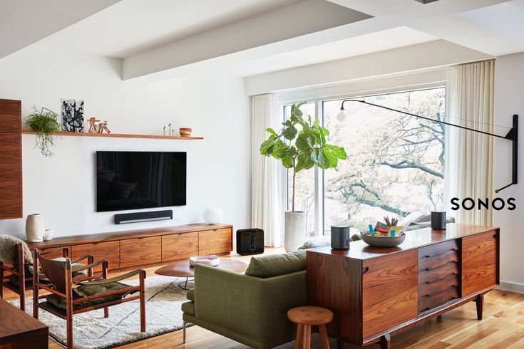 a living room filled with furniture and a flat screen tv on top of a wooden dresser