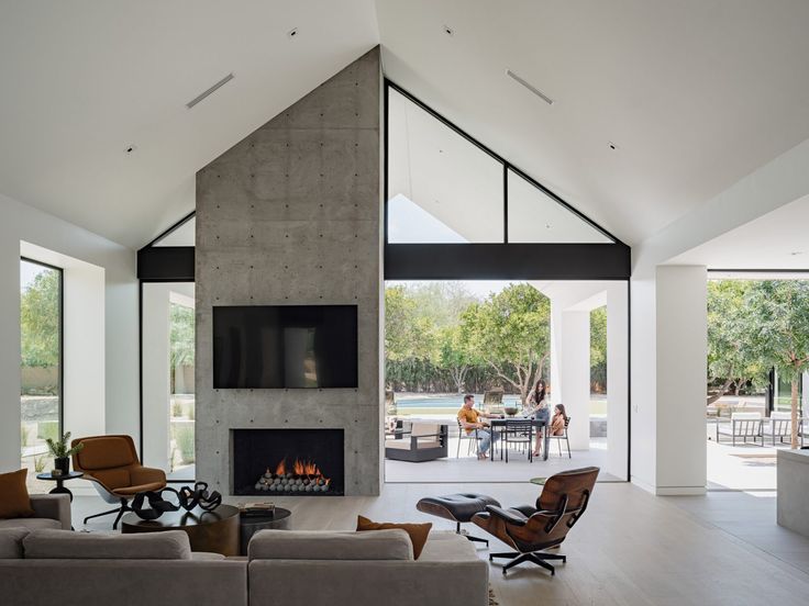 a living room filled with furniture and a fire place in the middle of a room