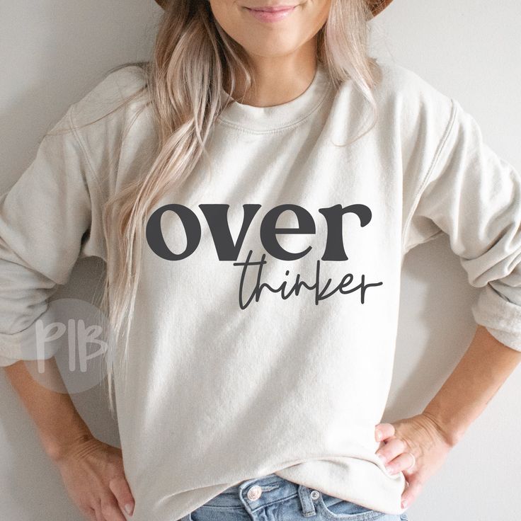 a woman wearing a hat and sweatshirt with the words over thinker printed on it