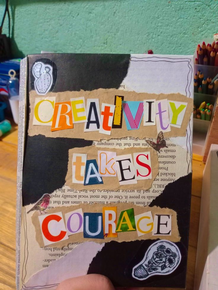 a person holding up a book with the words creativity makes courage written on it in multicolored letters