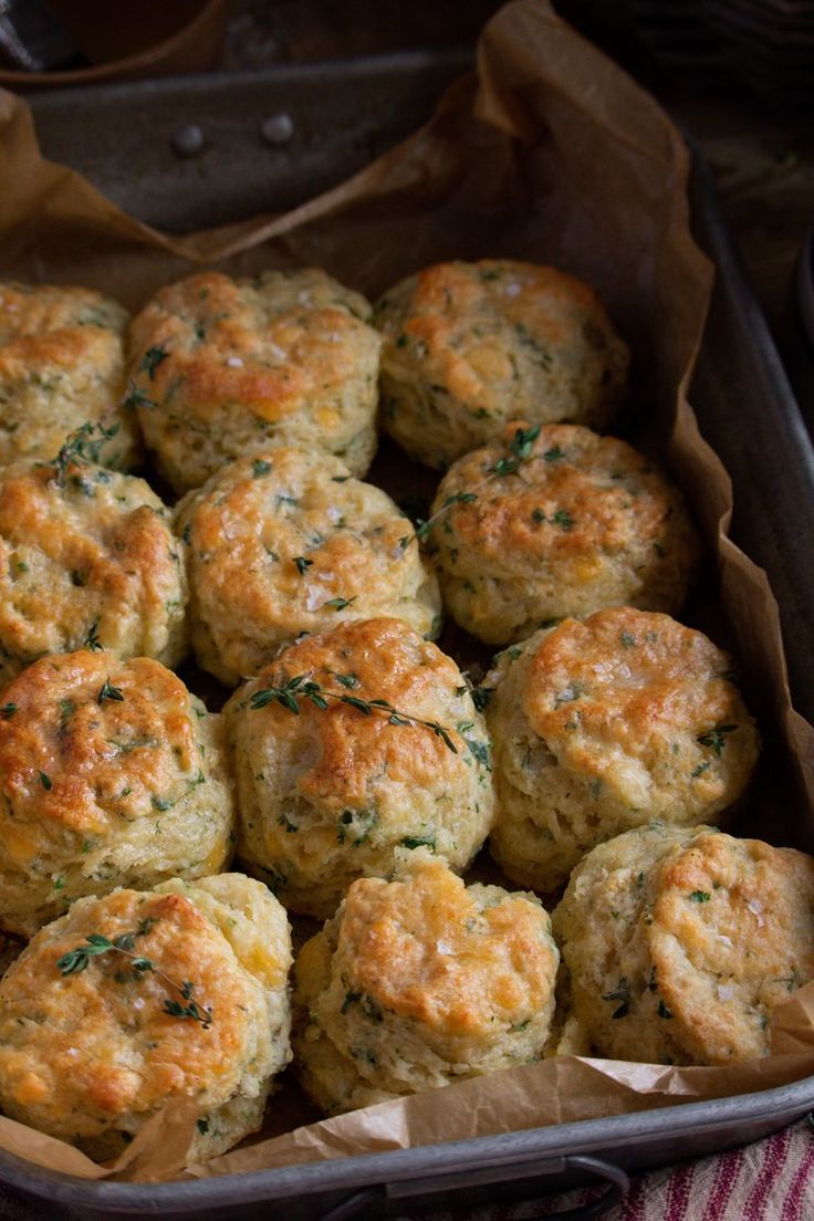 a metal pan filled with cheesy biscuits on top of a table