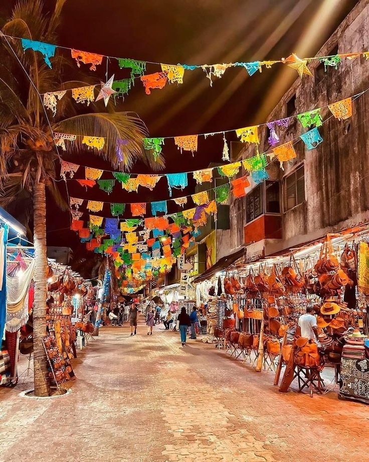 there are many colorful flags hanging in the street