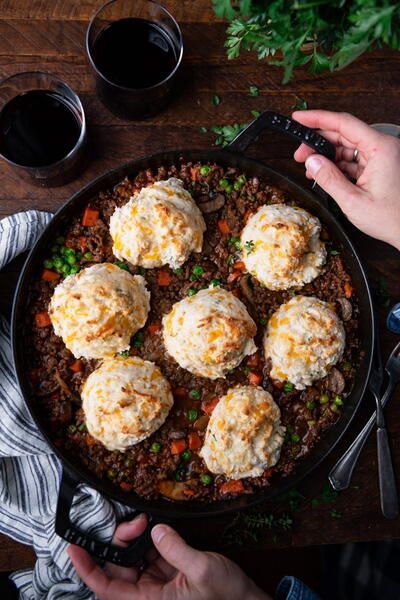 a person is taking a photo of some food in a skillet on a table