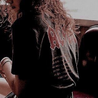 a woman with long curly hair sitting on a bus