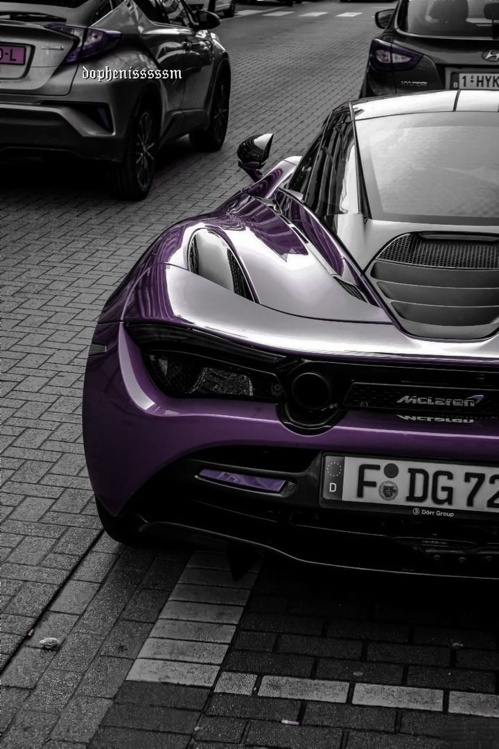 a purple sports car is parked on the street