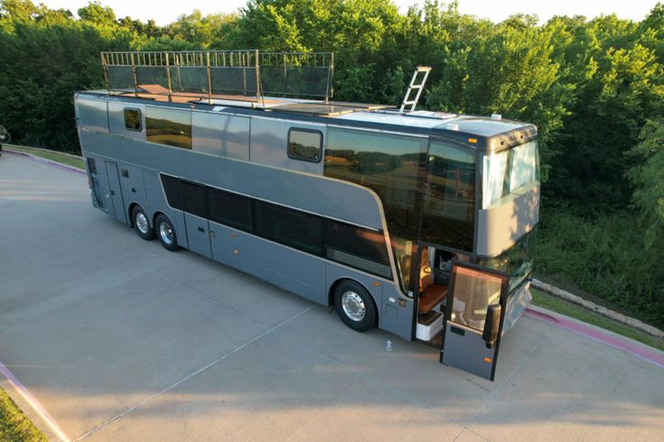 a double decker bus is parked on the side of the road with its doors open