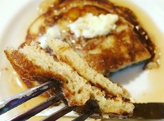 a plate with some pancakes on it and two forks sticking out of the top one