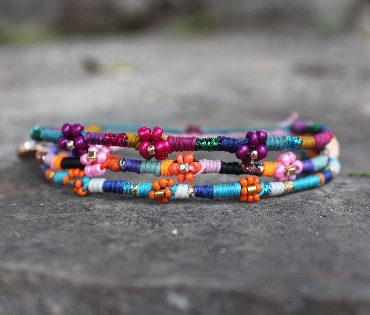 multicolored beaded bracelets sitting on top of a rock