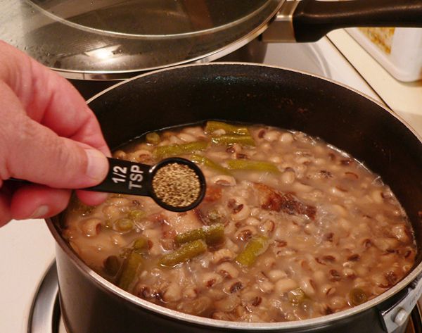 a person is stirring beans in a pot on the stove