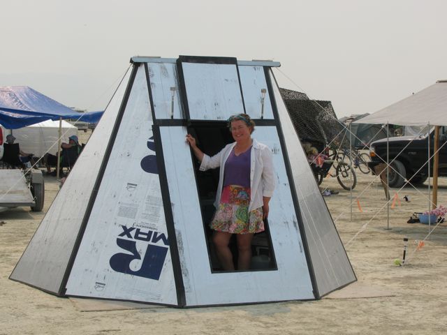 a man standing in front of a tent on the beach