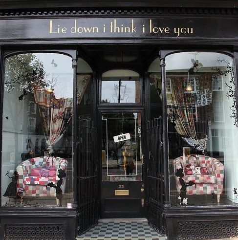 a storefront with two chairs in front of it and the words lie down i think love you