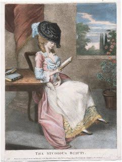 a woman sitting at a table reading a book