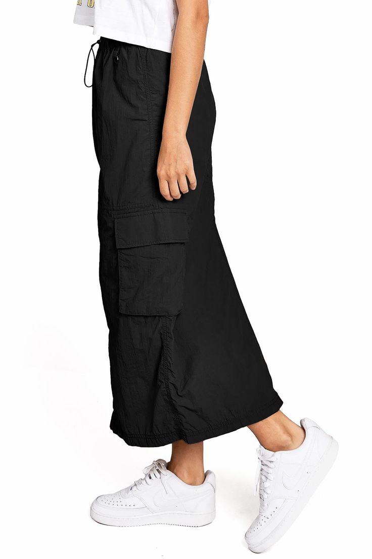 Chic, parachute skirt with an elastic waistband, a drawstring cinch tie and cargo pockets down the sides. Pair it with a graphic tee and sneakers for an effortless streetwear look. CARE | Machine Wash Cold CONTENTS | 100% Nylon MEASUREMENTS | 33"/85 cm Top to Bottom (Size Small) MODEL | 5'8 - wearing a size Small IMPORTED Parachute Skirt, Cargo Skirt, Top To Bottom, Graphic Tee, Graphic Tees, Street Wear, Elastic, Skirt, Sneakers