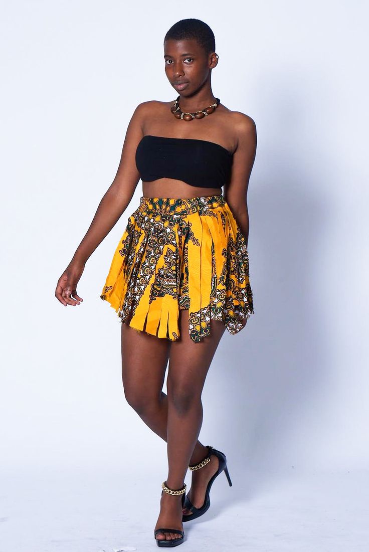 Photo of a woman wearing myObioma's yellow and high-waisted Dashiki Dancing Skirt with Frills. The dancing skirt with white and gold accented frills is printed with comfortable material for exaggerated movements. Fitted Gathered Skirt For Festival, Traditional Fitted Yellow Skirt, Yellow Fitted Traditional Skirt, Bohemian Fitted Mini Skirt With Elastic Waistband, Bohemian Style High Waist Lined Mini Skirt, Bohemian High Waist Lined Mini Skirt, High Waist Lined Bohemian Mini Skirt, High Waist Bohemian Mini Skirt With Lining, Yellow High Waist Pleated Skirt